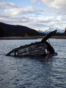 Submering SUV vehicle in a lake with trunk open. Entrapment and Vehicle Submersion.