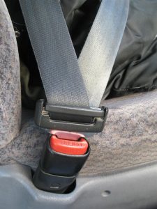 A vehicle seatbelt in use. Defective seat belts.