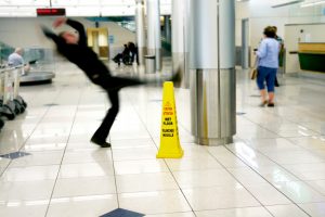 Man slips next to a yellow wet floor cone. Slip and fall.