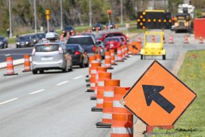 Orange move left signs and orange cones merging vehicle traffic to the left in a work zone. Work zone and construction zone accidents.