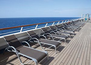 A row of empty chairs on the deck of a cruise ship on a clear sunny day. there has unfortunately been an increase in the number of injuries on board the vessels (slip and falls, negligent security, sexual assault, assault and battery, burns, explosions, pool drownings, off-ship excursions injuries, and wrongful deaths).
