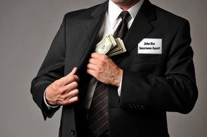 An insurance agent putting money in his pocket. Learn abou auto insurance companies’ claims tactics of Delay ~ Deny ~ Defend.