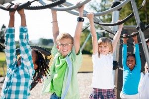 Children at a playground playing on the monkey bars. Here are some safety tips to help keep your child safe while on a playground.