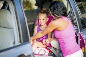 A mom securing her child in a child safety seat. Florida's new child booster seat law is now in effect