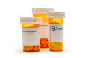 Three standing prescription drug bottles. Dangerous and defective medication.