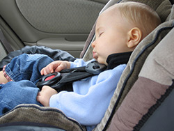 A yound child asleep in a child safety seat. There is no safe amount of time to leave children alone in the car.