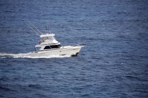 White fishing boat crusing the ocean. The Safe Boating bill offers boaters a state vessel registration discount for buying and registering emergency locator devices.