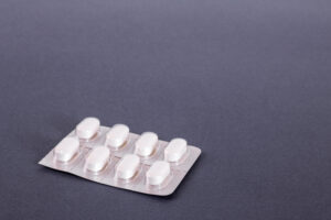White tablets in a blister, on a dark background