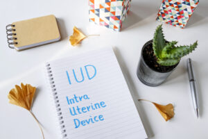 IUD Intra Uterine Device written in notebook on white table