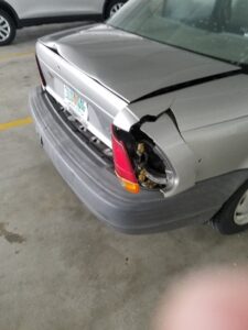 Grey sedan with rear-end damage.