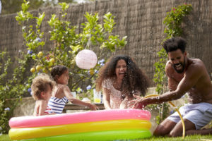 Family Having Fun In Garden Playing in a kiddie pool