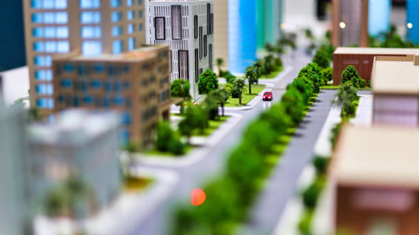 modern generic contemporary style miniature model of glass buildings and streets with tilt-shift focus technique - focus is on the red car in the middle of the street