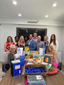 Murray Guari Staff with items raised for Back to School Bash
