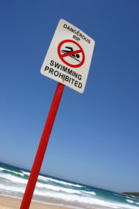 Red and white beach sign - swimming prohibited