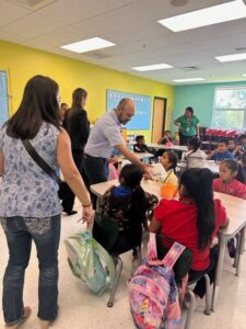 Partner Scott Perry distributes school supplies to students at Highland Elementary School