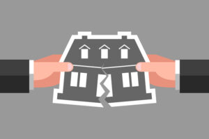 Two hands are tearing icon of house over gray background. Concept of division of property, real estate, inheritance partition