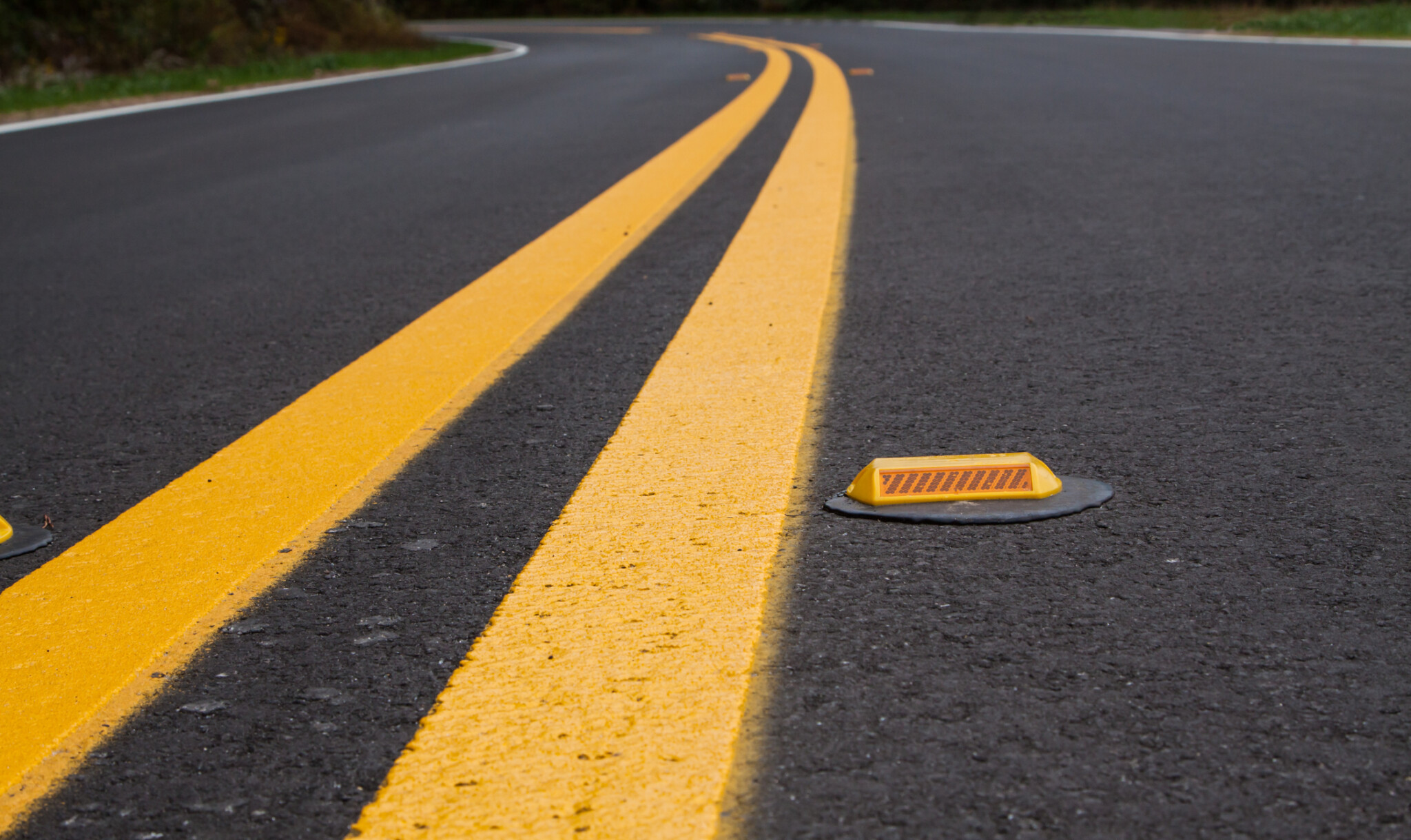 Roadway devider lines and markers with a yellow road reflector