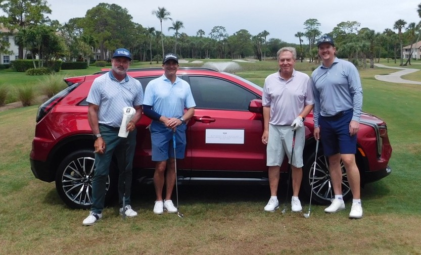 Attorneys Jason Guari and Keith Hedrick in front of sponsor car at Golf Classic for YMCA