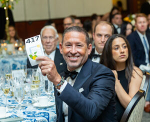 Scott Murray at Legal Aid Gala holding winning ticket