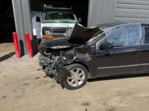 Car Accident Photo - Black four-door car with major front end Damage